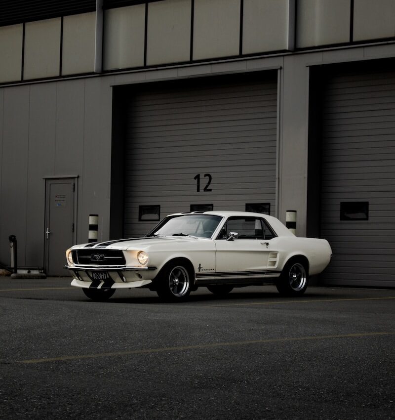 white chevrolet camaro parked in front of garage